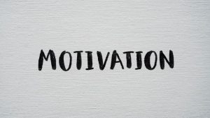 Inspirational word 'Motivation' in black on a white textured canvas background.